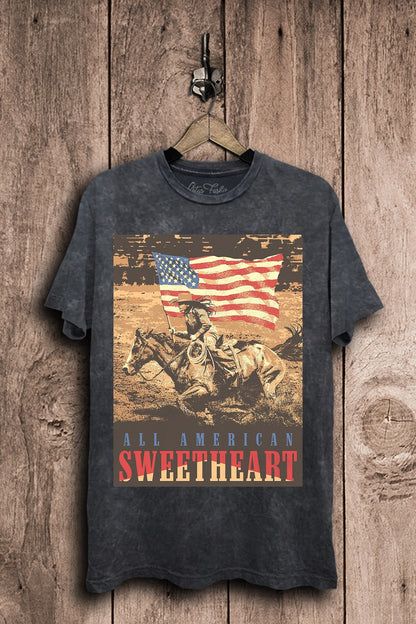 Vintage black mineral-wash boyfriend tee featuring a cowgirl riding on horseback beneath an American flag with All American Sweetheart lettering.