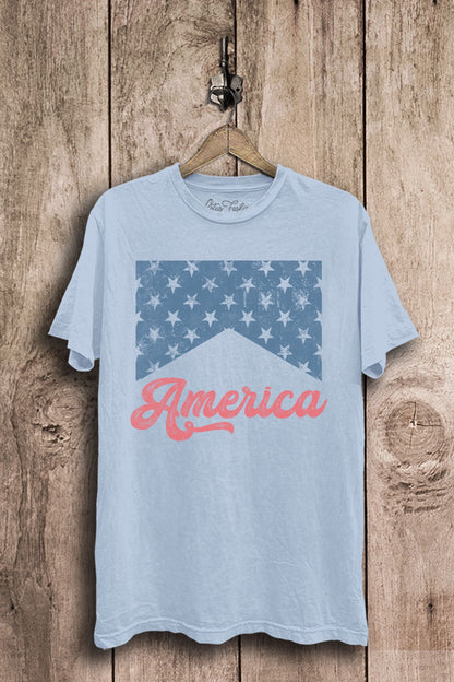 Light blue mineral-washed boyfriend tee featuring a distressed blue star-banner graphic and coral America script lettering.