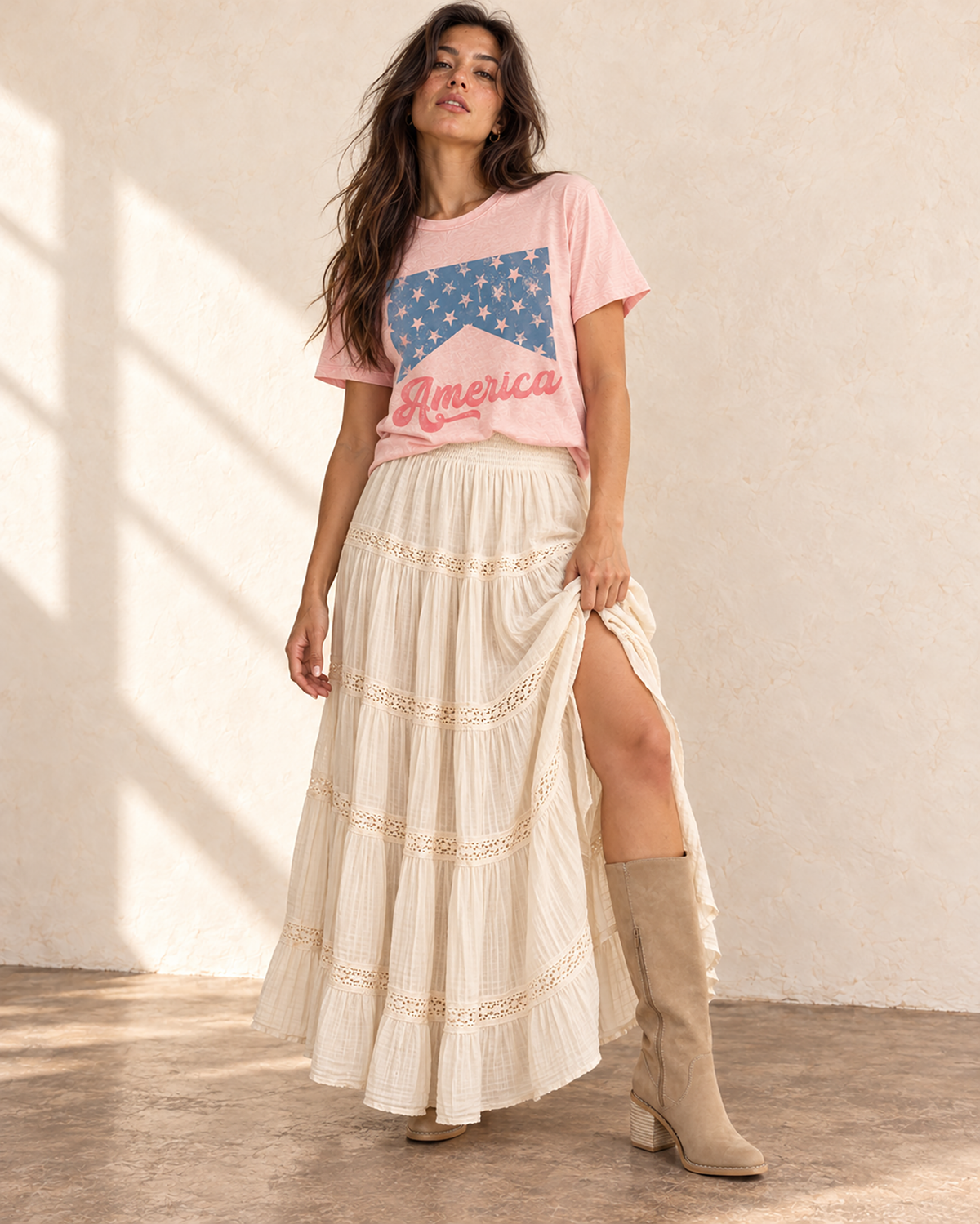Light pink mineral-washed boyfriend tee featuring a distressed blue star-banner graphic and coral America script lettering.