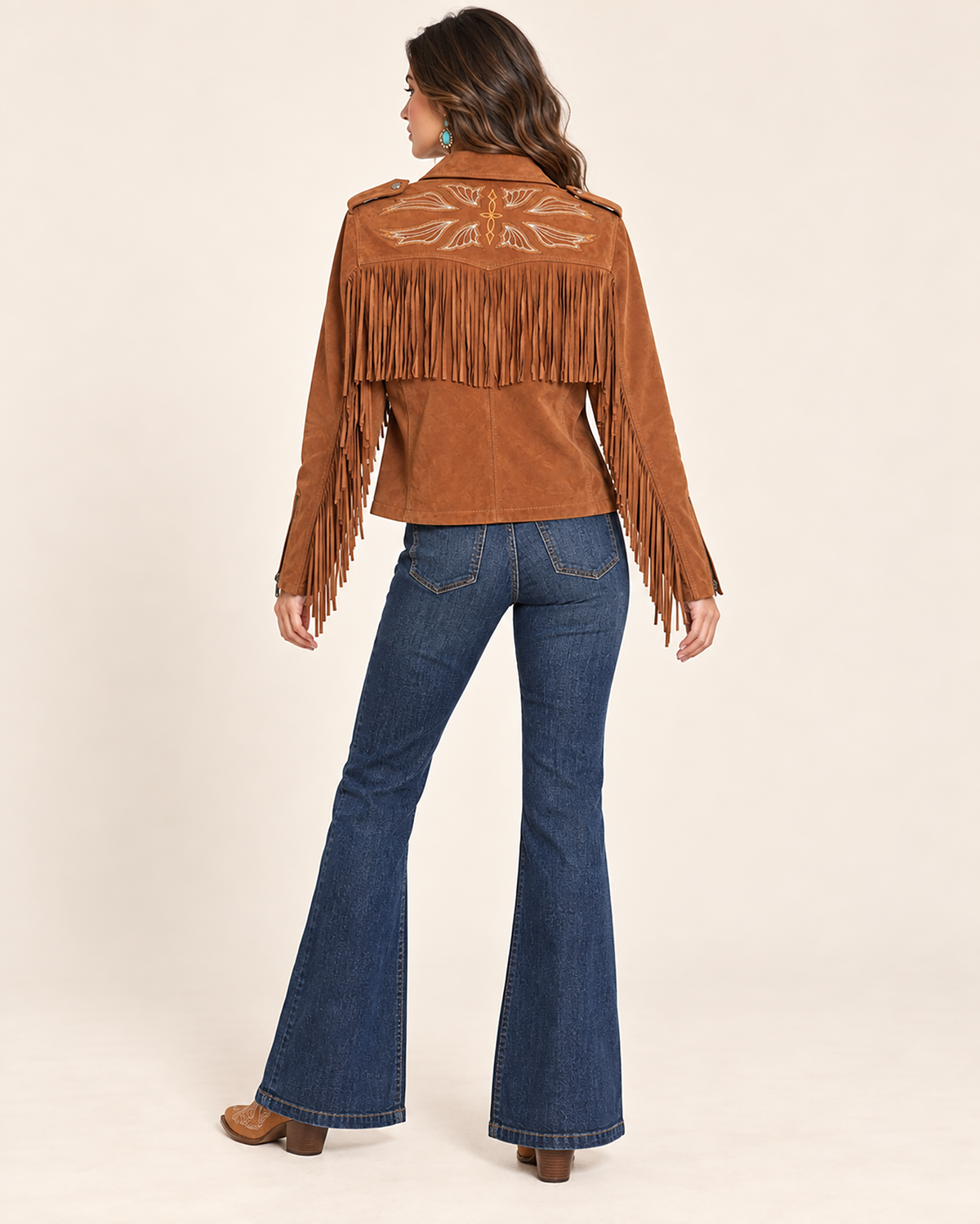 Brown suede leather western jacket with cascading fringe, an asymmetric zip front, snap lapels, and shoulder epaulettes.