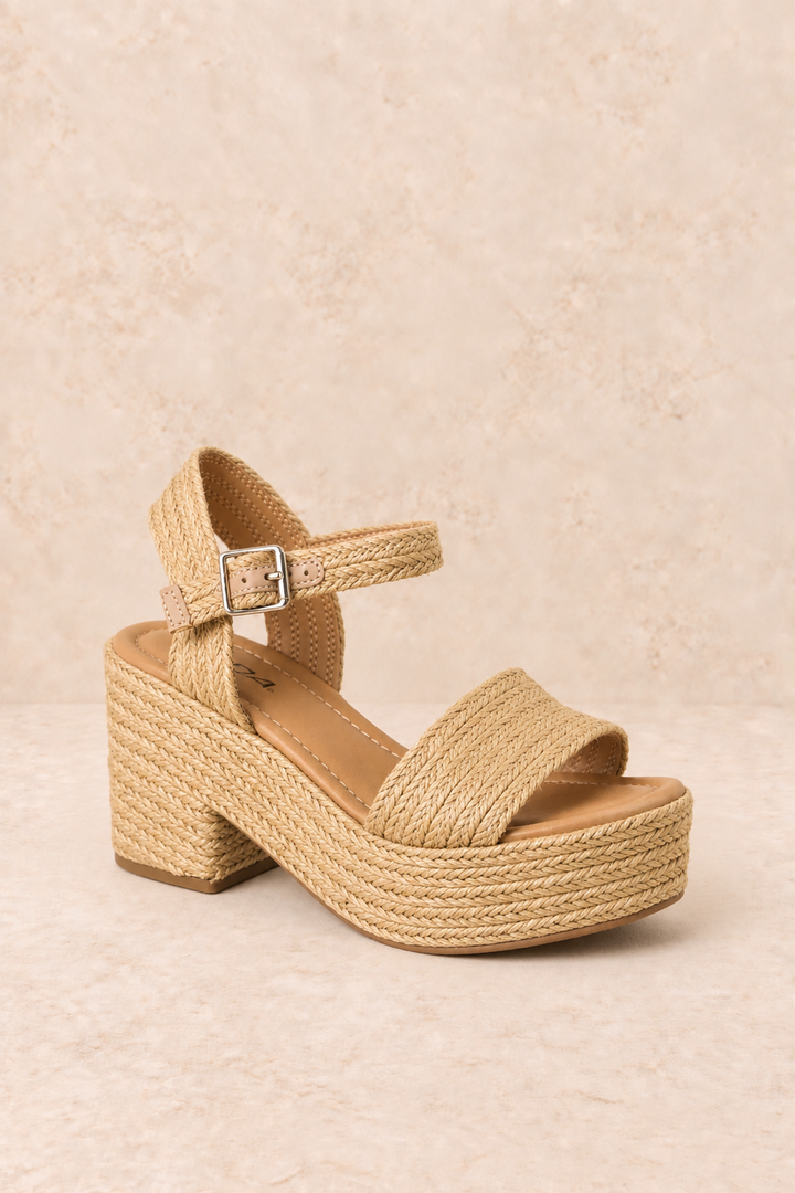 Natural woven raffia platform sandal with a wide front strap, adjustable ankle buckle, cushioned footbed, and chunky block heel.