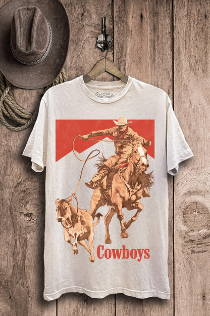 Off-white mineral-wash plus-size boyfriend tee featuring a cowboy on horseback roping cattle with bold red western accents.