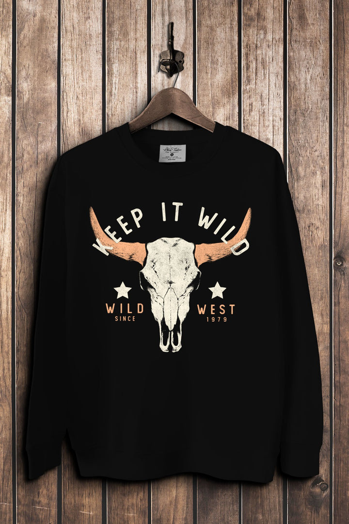 Black French terry crewneck sweatshirt featuring a distressed cow skull with rust-colored horns, stars, and Keep It Wild lettering.