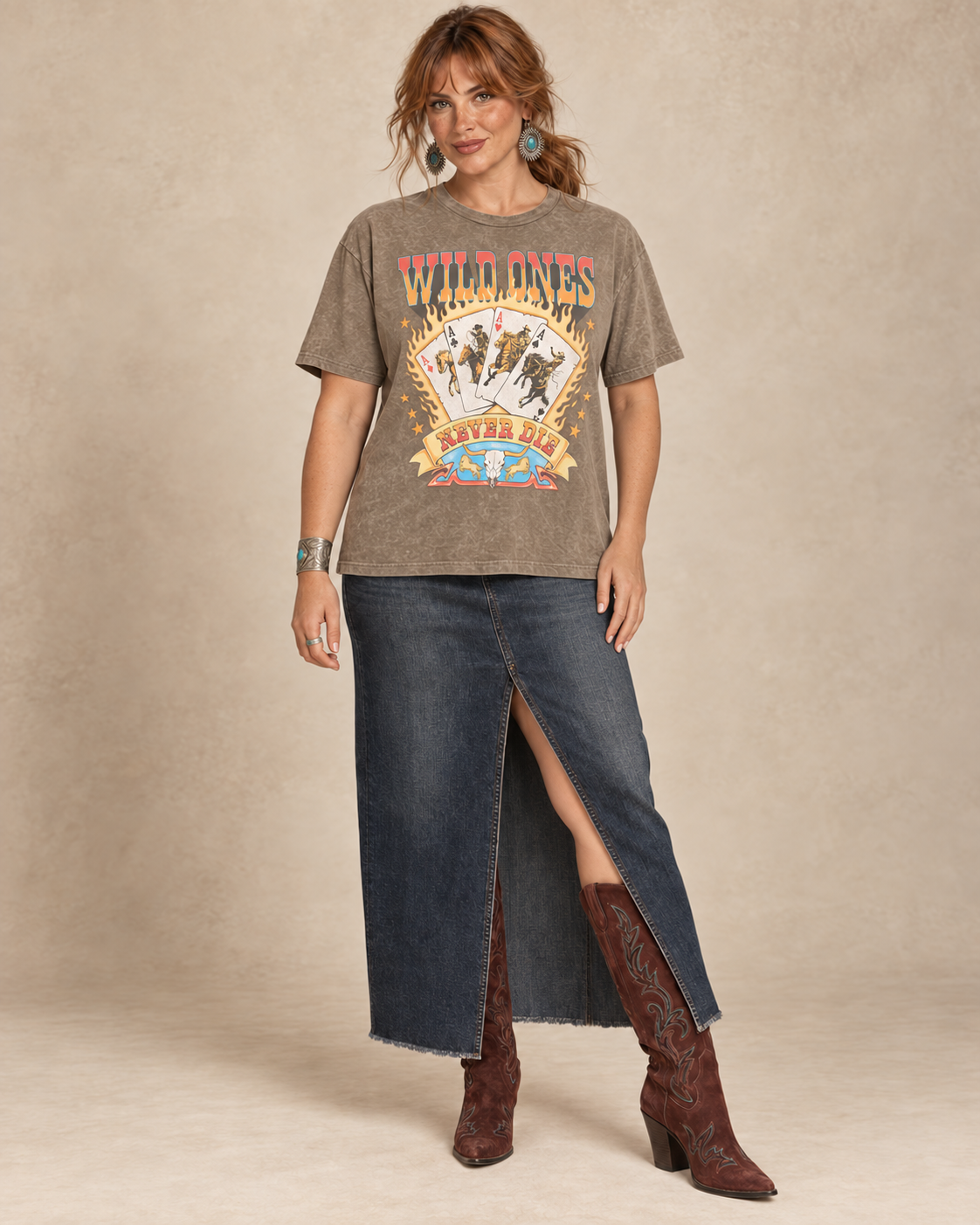 Mocha mineral-wash boyfriend tee featuring Wild Ones Never Die lettering, flaming cowboy playing cards, stars, and a longhorn skull.
